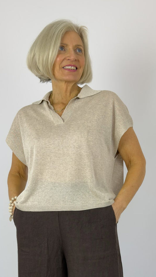 Woman wearing a beige top and brown wide-leg pants on a white background
